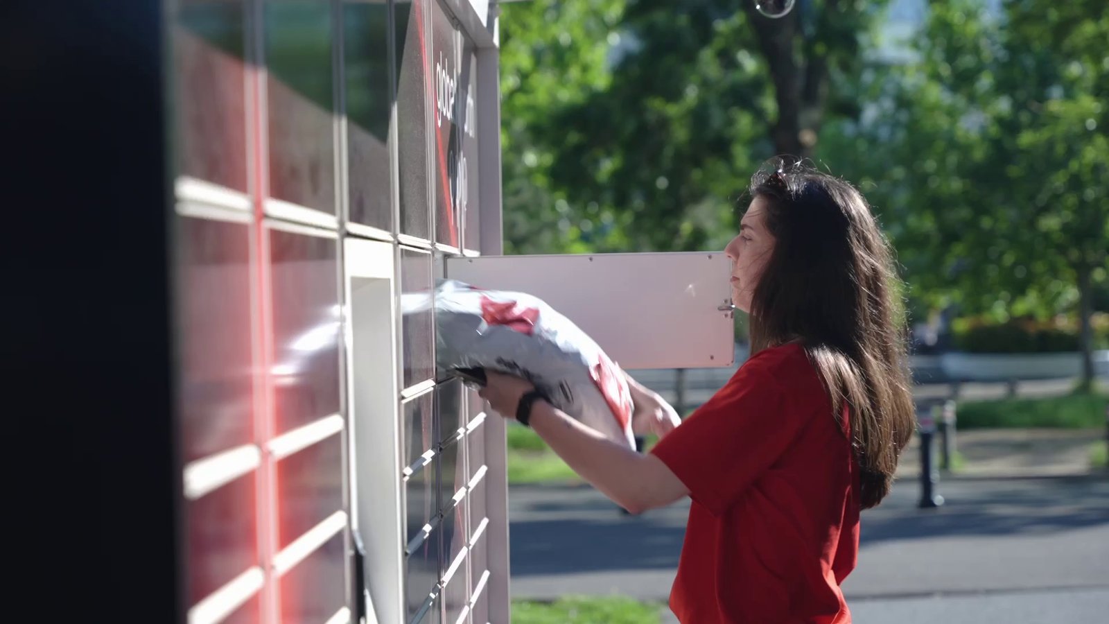 A woman placing a parcel in a Sameday easybox